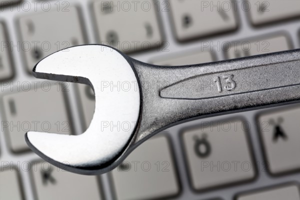 A spanner as a tool on a computer keyboard. Symbolic photo for data protection, online crime, and security on the Internet