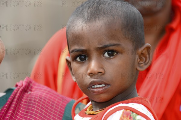 Coastal temple of Mahabalipuram, Mamallapuram, A child in red clothes with a curious and serious expression on his face, Mahabalipuram, Tamil Nadu, South India, India, Asia