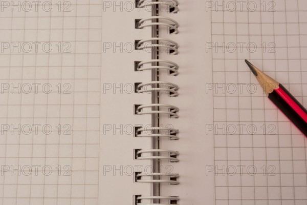 White empty notebook with pencil on top of it