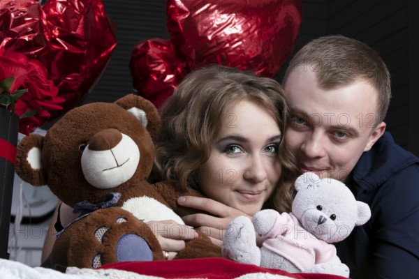 Boyfriend and girlfriend on Valentine's Day. Portrait of lovers. A man and a beautiful woman with flowers and bears