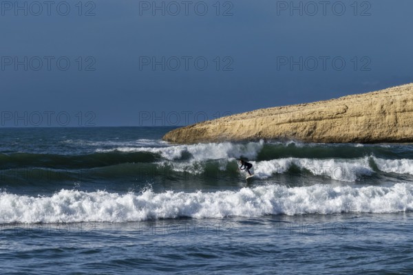 Santa Caterina di Pittinuri, Italy, 13 December, 2022: surfer enjoying good waves on the west coast of Sardinia during a good winter swell, Europe