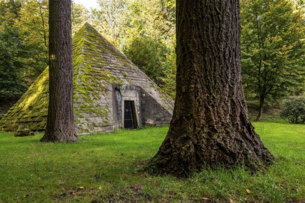 Pyramid-shaped, moss-covered mausoleum, surrounded by tall trees, mystical atmosphere, Hämelschenburg Castle, Weserbergland, Lower Saxony, Germany, Europe