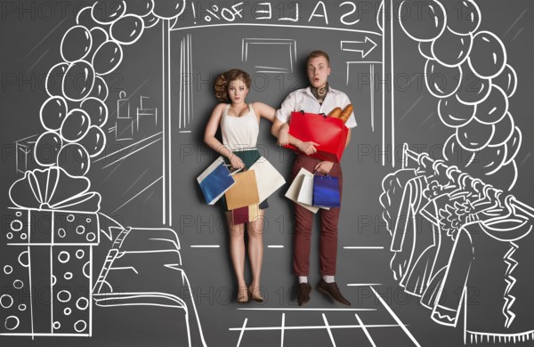 Love story concept of romantic couple on shopping against chalk drawings background. Young couple with shopping bags entering a shopping centre during the sale