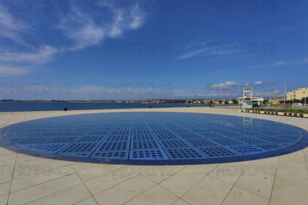 Modern circular solar installation by the sea with clear sky and calm surroundings, artwork Greeting to the sun Zadar Dalmatia Croatia