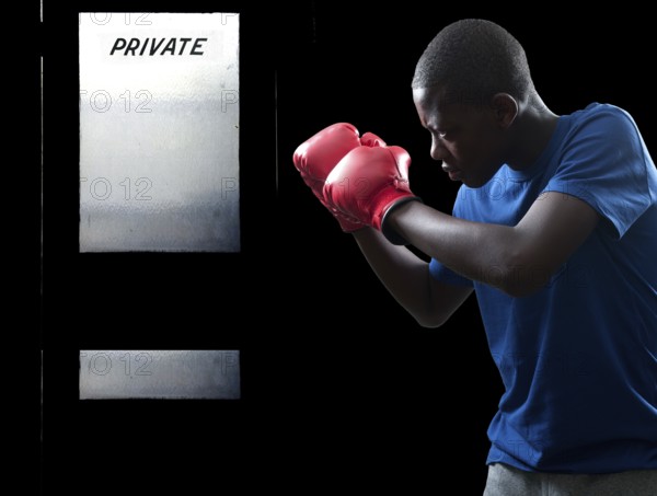Black African American teenage boy athletic boxer with boxing gloves