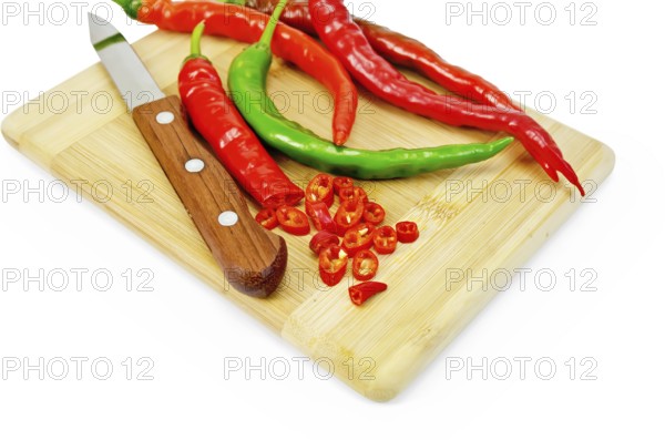 Hot pepper red and green with a knife on a wooden board isolated on white background