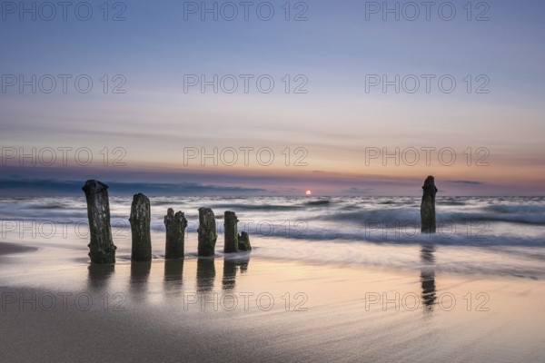 Groyne on the coast of the Baltic Sea with sunset