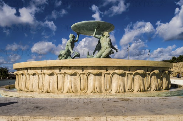 The famous Triton fountain, three bronze Tritons holding up a huge basin, in front of the City Gate in Valletta, sizable landmark fountain featuring multiple bronze tritons on a stone base, Valletta