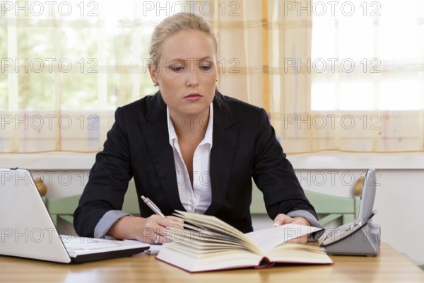 Successful young entrepreneur at her desk with Bruch and Laptop Computer Austria