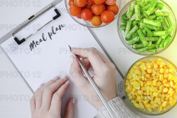 Meal plan. Three Bowls of frozen vegetables food of yellow corn, green beans, red tomatoes. Colors of traffic light. Harvest Food preservation for winter. Copy space