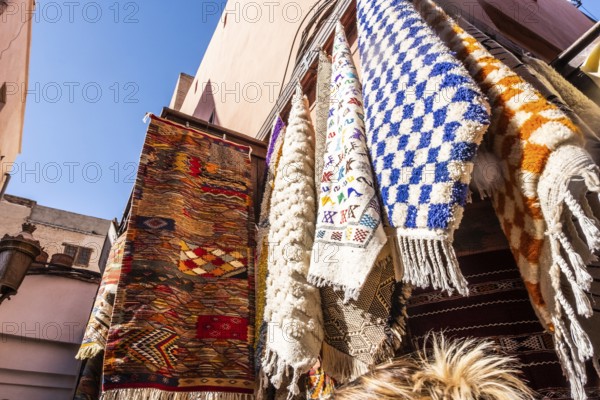 Colorful yellow, blue, red and green carpets in a shop in a souk in Marrakech. Morocco