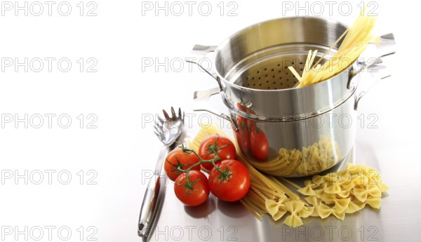Stainless steel pot with uncooked pasta and tomatoes