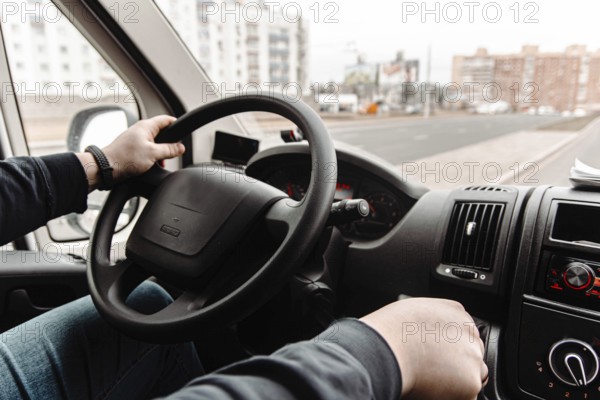 Driver in a vehicle navigating through urban roads during daytime