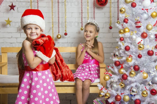 Two funny sisters four girls and six years of playing and having fun in the home New Years interior