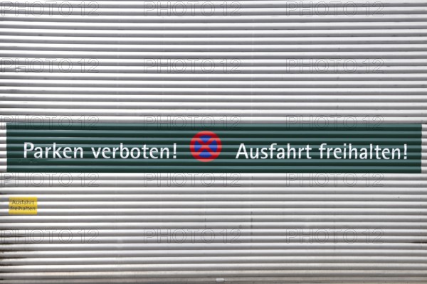 Rolltor mit der Aufschrift "Parken verboten und Ausfahrt freihalten" auf Deutsch