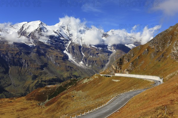 Famous picturesque views of the road in Austrian Alps - Grossglocknershtrasse. Ideal highway winds high in the mountains. The highest mountain peaks covered with fresh snow