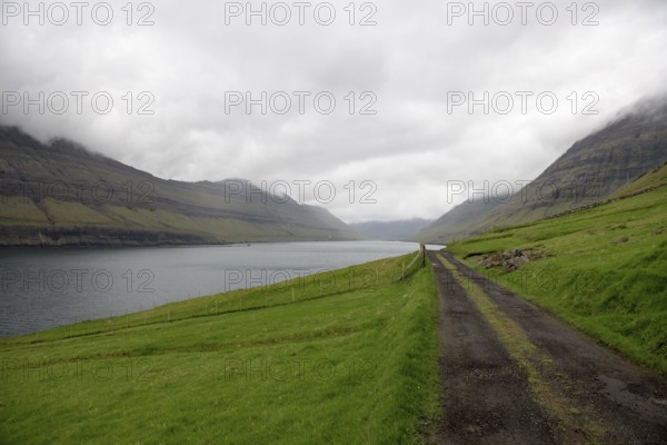 Gravel street on the Faroe Islands with the village Hvannasund in the background, Hvannasund, Faroe Islands, Europe