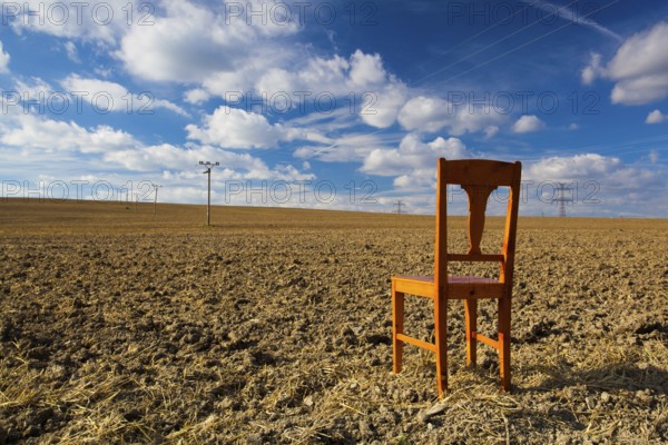 Old wooden chair on the empty field after harvest