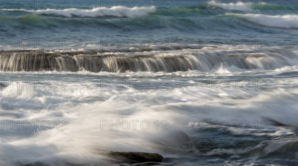 Rocky seashore with wavy ocean and waves crashing on the rocks at Akrotiri coast area in Limassol, Cyprus, Europe