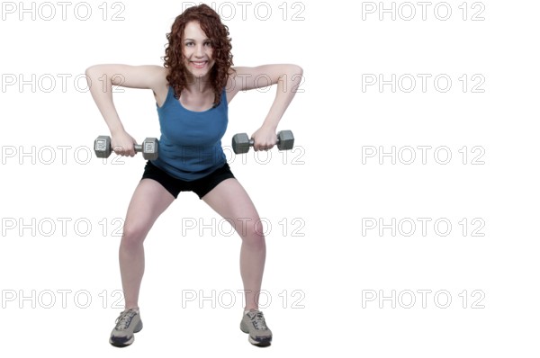 A beautiful young woman using weights during a workout
