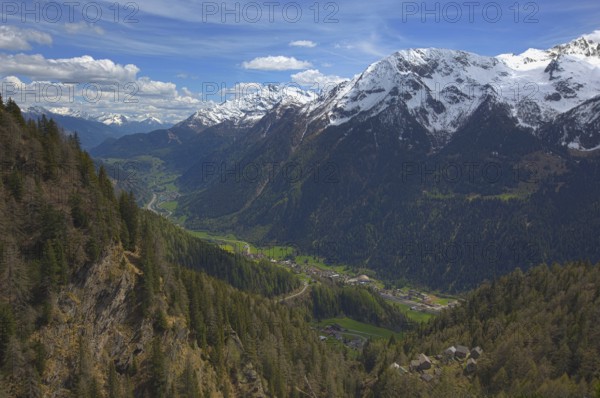 Beautiful top view of high snow-covered mountains and valley with road and village in Switzerland