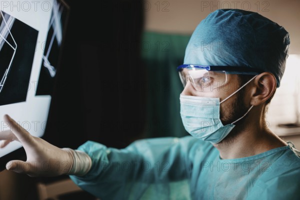 Medical professional scrutinizing x-ray with measured focus