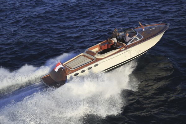 Aerial view sports boat J Craft 42 Torpedo R at full speed on the Cote d'Azur, luxurious motorboat from the Swedish shipyard J Craft Boats with Volvo Penta engine in vintage style of the 50s and 60s in the style of the Riva boats, Mediterranean Sea