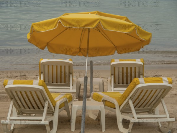 Yellow deckchairs and parasols on a quiet beach, Cannes, mediterranean sea, france