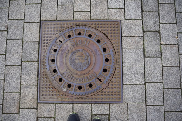 Manhole cover with motif on John the Baptist, Bible, town coat of arms, coat of arms, Künzelsau, Kocher valley, Kocher, Hohenlohe, Germany, Europe