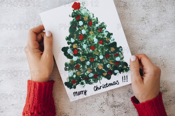 DIY Making greeting card Handmade crafts on holiday for children. Paint with fingers Merry Christmas tree. Top view. Step by step. Do it yourself. Happy New Year xmas tree decoration