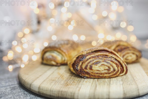 Cinnamon pastries on a wooden board with soft glowing lights