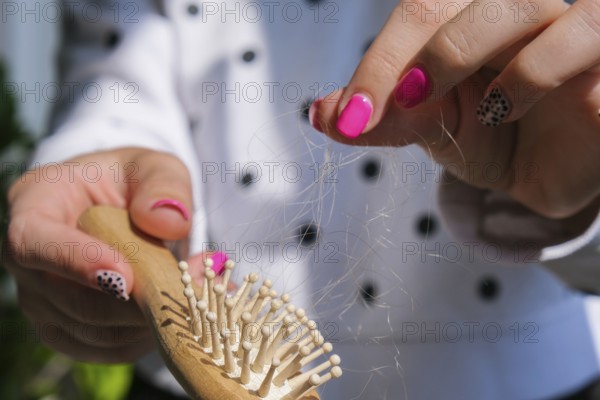 Hair loss on the comb, massage wooden brush with a clump of hair, problem of growth, hair care problems. Hair loss it cause from family history, hormonal changes, unhealthy of aging