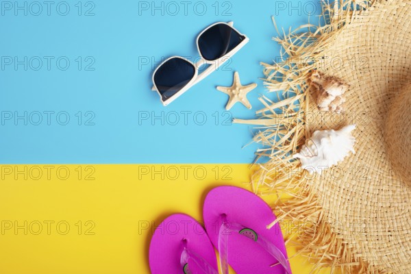 Straw hat sunglesses flip flops and shells on yellow and blue background vacation travel planning mockup
