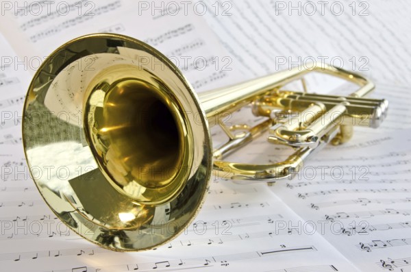 Closeup of trumpet lying on sheet music