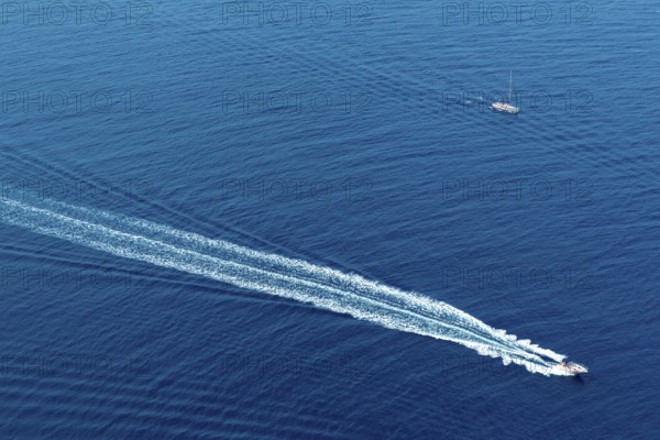 Boat surf foam aerial from prop wash in blue Majorca mediterranean sea