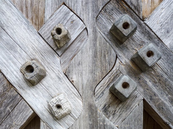Weathered wooden planks intersecting with decorative square pegs showcasing traditional joinery techniques