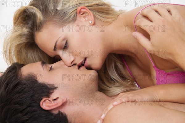 Couple in bed during sex and tenderness. Love and eroticism in the bedroom. Austria