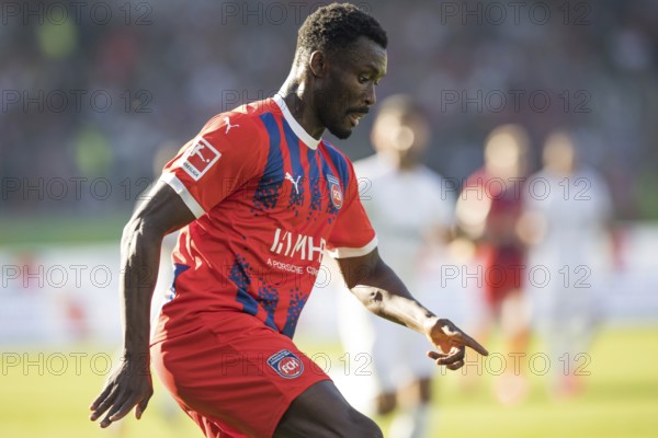 Football match, Sinlord CONTEH 1. FC Heidenheim looking down at the ball and pointing downwards, football stadium Voith-Arena, Heidenheim