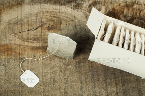 Box with tea bags on wood. Tea bag with label