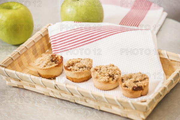Magnificent portioned shortbread baskets with sweet stuffing. Professional baking. Background of a wicker basket and a white dish towel