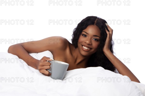 Beautiful happy smiling african woman in white bed waking up with coffee or tea after a deep sleep, Atlanta, USA, North America
