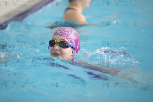 Child athlete swims in the pool. Swimming section