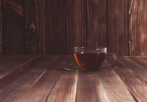 Glass cup of tea on a wooden table