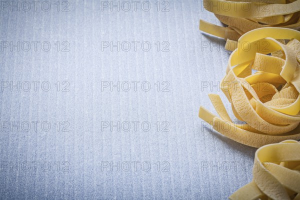 Copy space of rolled pasta fettuccine on blue background food and drink concept
