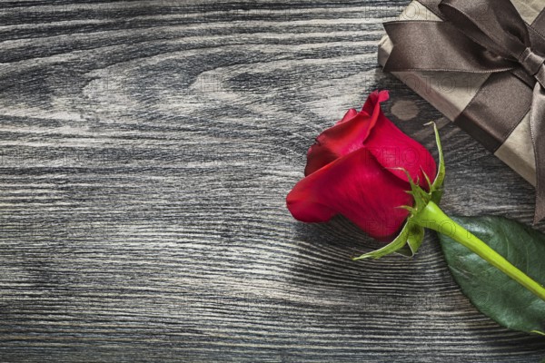 Red rose gift box on wooden board holidays concept