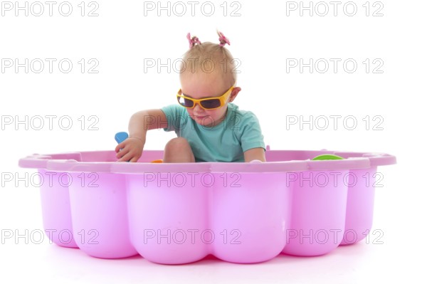 Toddler girl playing in swimming pool isolated over white background
