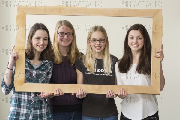 Group of girls smiling through a picture frame - portrait