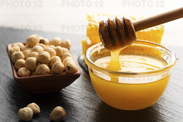 Slate tray with honey hazelnuts and honeycomb on kitchen table, food photography, food photography