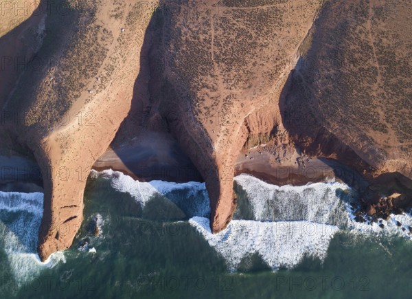Aerial top view on Legzira beach with arched rocks on the Atlantic coast at sunset in Morocco