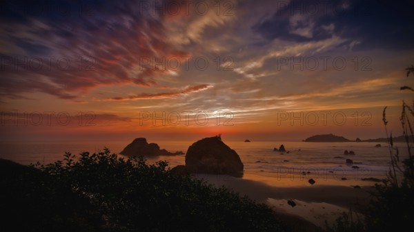 This is a color landscape photo of a vivid sunset over the Pacific Ocean